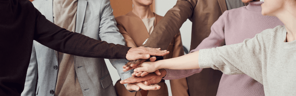 Featured image for What Is DEIB? showing a group of people with their hands together.