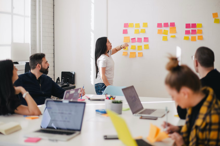 5 Employee Development Strategies that Will Increase Retention 4 Employee development meeting in office with sticky notes.