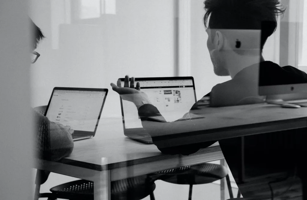 Learning culture with employees talking in front of computer.