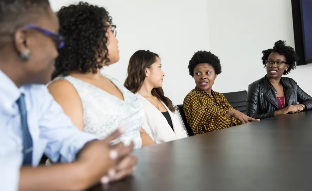 Reverse mentoring with a group of BIPOC employees meeting and discussing around a conference table. 