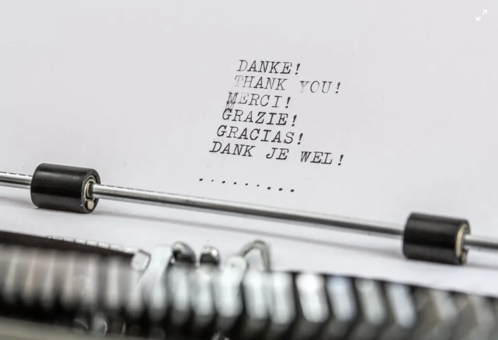 Expressing Gratitude in Mentoring 3 Typewriter with Thank you typed in different languages.