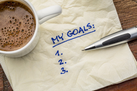 My goals list on a napkin with cup of coffee