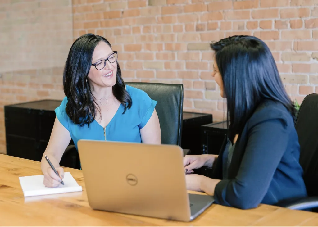 5 Ways to Make Mentoring a Personalized Learning Experience 5 Two women in a mentoring relationship sitting at a table in a office discussing development and mentoring goals
