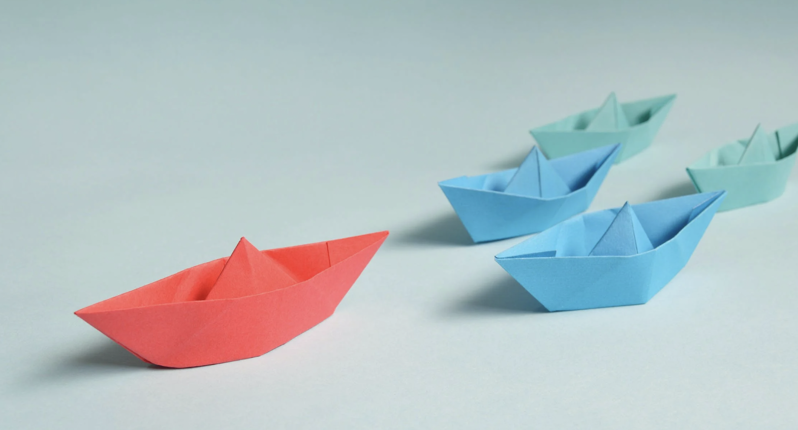 Paper ships of different colors representing good mentors.