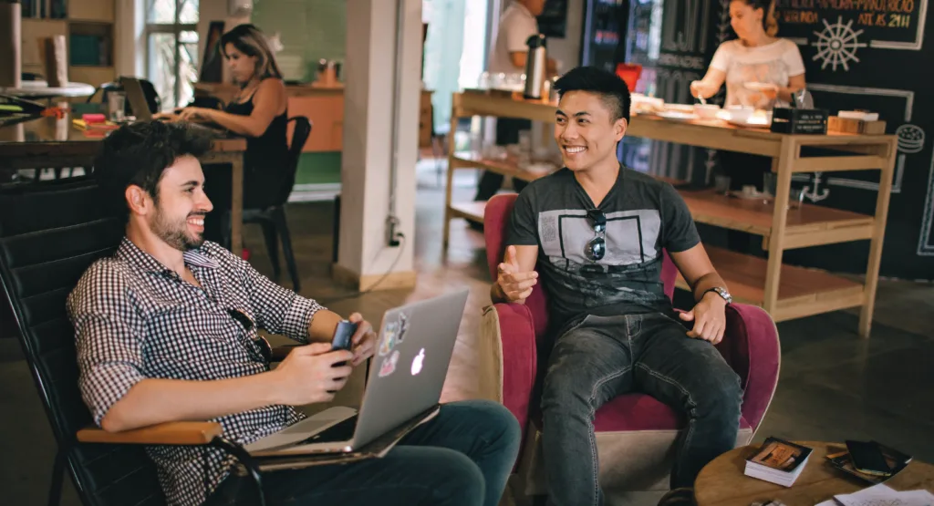 Two men talking at a coffee shop engaging in good mentor relationships.