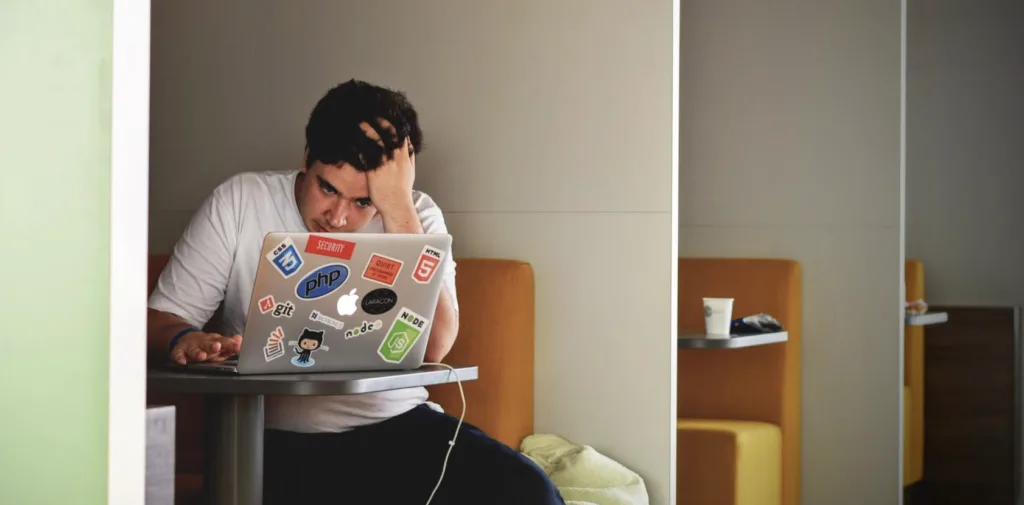 Worker at a table stressed from poor team culture.