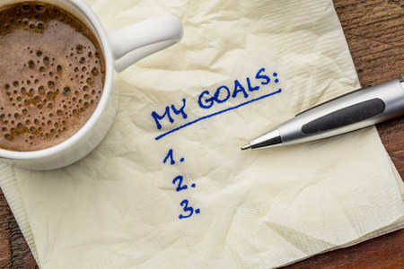 my goals list on a napkin with cup of coffee