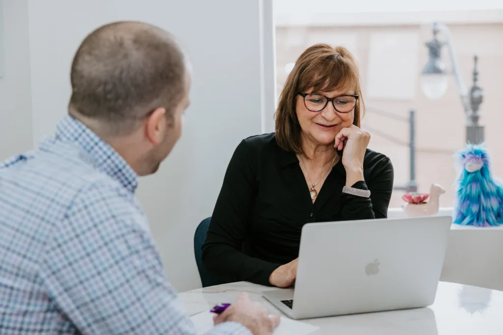 Man and woman in a meeting discussing how to reduce the cost of training new employees.