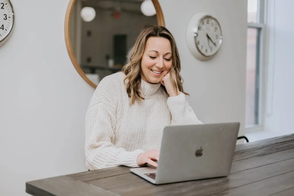 A woman sitting in an office at a desk, working on a mentoring agreement at the computer. 