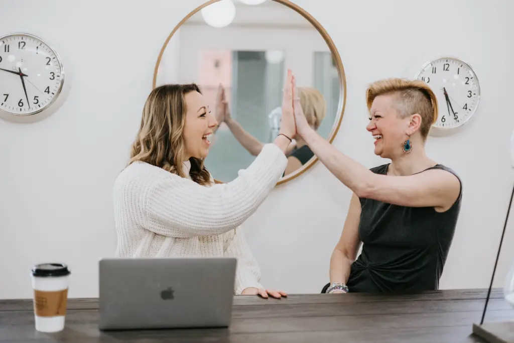 Two women in an women's employee resource group giving each other a high five.