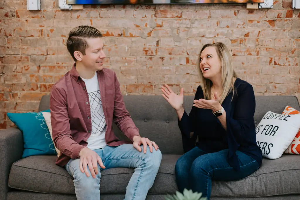 A mentor and mentee sitting on a couch discussing how to end a mentoring relationship.